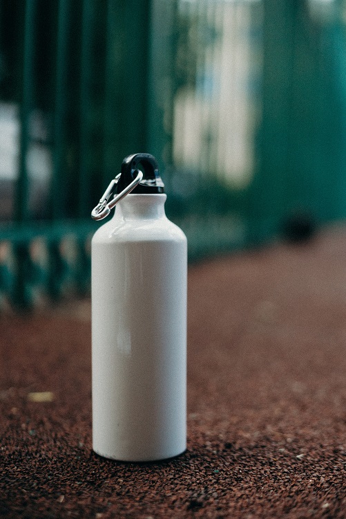 A white water bottle sitting on the ground.