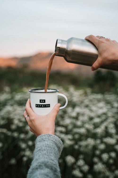 A person pouring liquid into a mug.